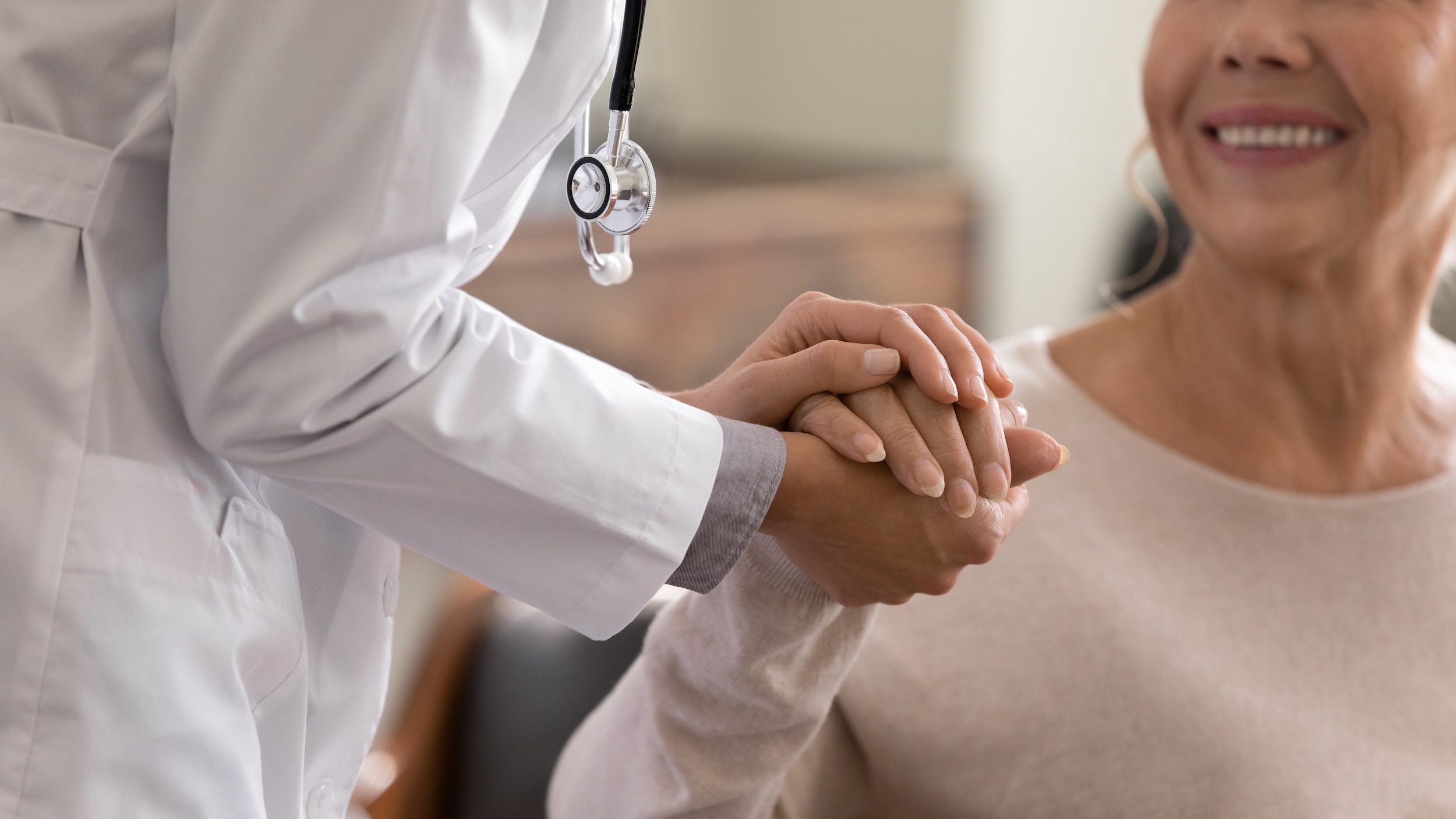 doctor and patient holding hands